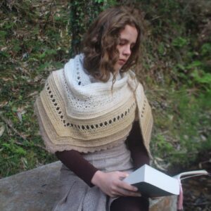 Chica luciendo el Chal Ouveo leyendo un libro
