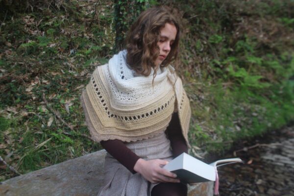 Chica luciendo el Chal Ouveo leyendo un libro